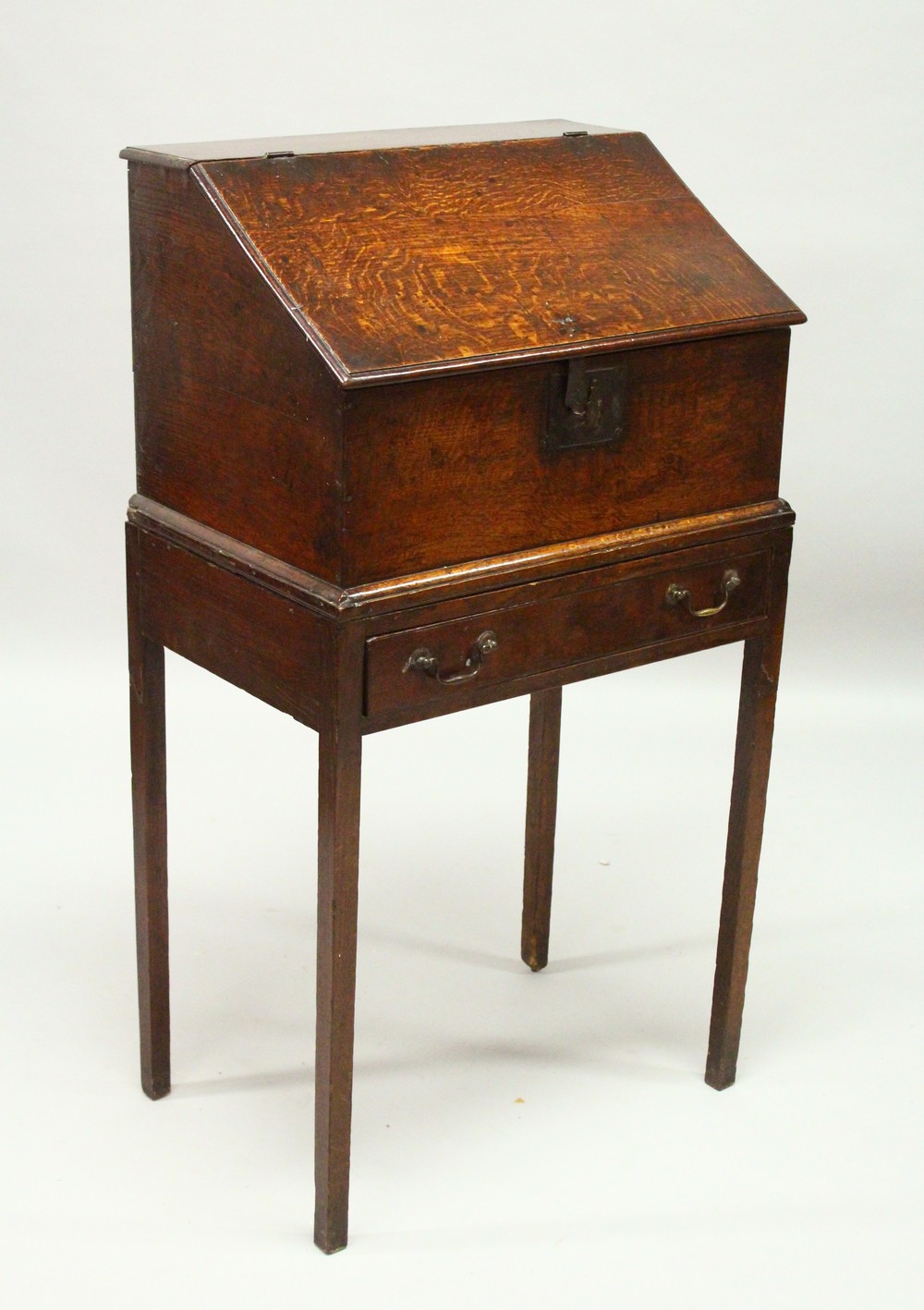 AN 19TH CENTURY OAK DESK ON STAND, with sloping front, fitted interior with small drawers, on a