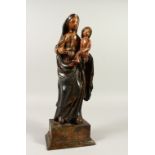 A 17TH CENTURY CARVED AND PAINTED FIGURE GROUP, Virgin and Child, on a faux marble base. 43cm high.