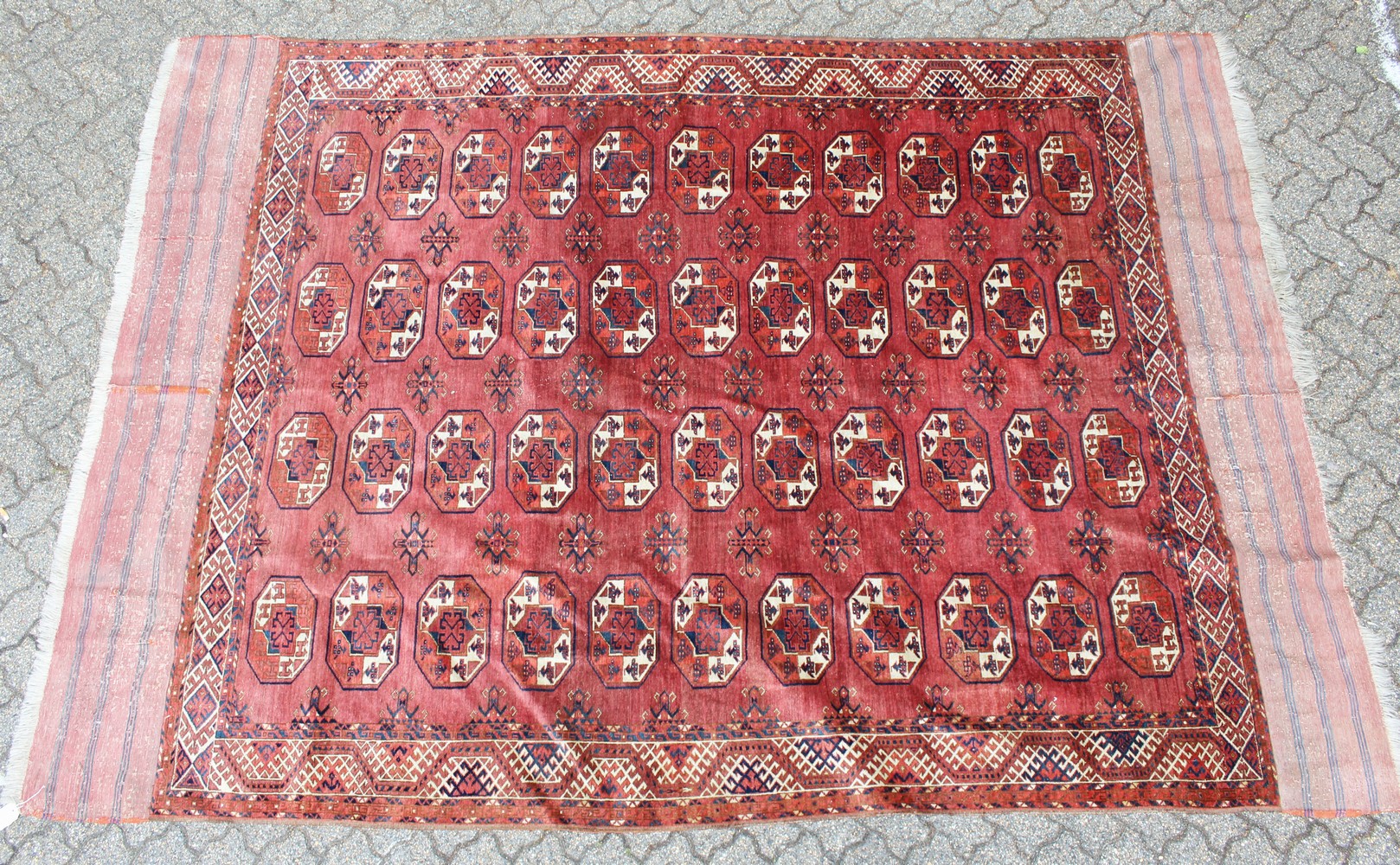 A LARGE TEKKE BOKHARA RUG, rust ground with four rows of eleven gulls, and broad end fringe. 135cm x