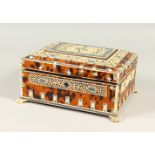 AN ISLAMIC IVORY AND TORTOISESHELL BOX, with fitted interior on four claw feet. 23cms long.