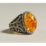 A SILVER AND AMBER RING.