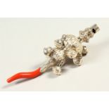 AN ORNATE SILVER AND CORAL RATTLE.