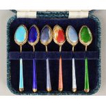 A SET OF SIX CASED SILVER AND ENAMEL SPOONS.