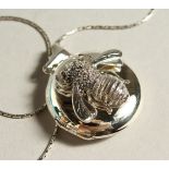 A SILVER BUMBLE BEE LOCKET AND CHAIN.