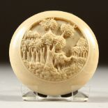 A CARVED IVORY CIRCULAR COMPACT. 7cms diameter.