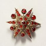 A GARNET SET STAR BROOCH.