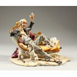 A GOOD CAPODIMONTE PORCELAIN GROUP, old man on a chaise longue, a playful dog by his side. 22cm
