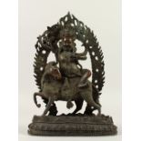 AN EASTERN BRONZE GOD, seated on a horse. 30cms high.