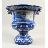 A LARGE FRENCH FAIENCE PEDESTAL VASE, decorated with a huntsman and buildings in a landscape.