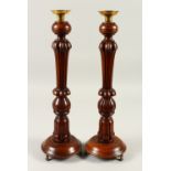 A PAIR OF WOODEN CANDLESTICKS. 43cms high.