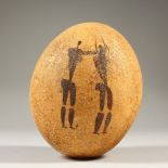 AN EMU EGG, naively painted with hunting figures. 14cms high.