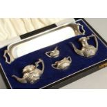 A MINIATURE SILVER FIVE PIECE TEA SET, in a leather case.