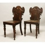 A GOOD PAIR OF LATE REGENCY MAHOGANY HALL CHAIRS, with shaped backs, solid seats, on curving legs.