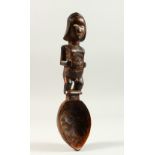 A GOOD CARVED WOOD TRIBAL SPOON with bone eyes. 24cms long.