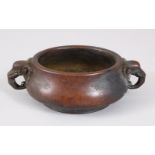 A SMALL CIRCULAR BRONZE CENSER, with elephant head handles. 14cms wide.