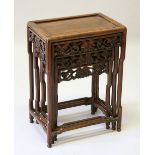 A CHINESE NEST OF THREE TABLES, the sides pierced and carved with fruiting vines.