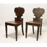 A GOOD PAIR OF REGENCY MAHOGANY HALL CHAIRS, with shaped backs, solid seats, on turned legs.