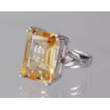 A LARGE SILVER EMERALD CUT CITRINE RING.