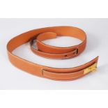 A HERMES TAN LEATHER BELT, in a HERMES BAG.