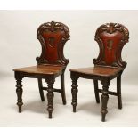 A GOOD PAIR OF LATE REGENCY MAHOGANY HALL CHAIRS, with shaped and pierced backs, solid seats, on