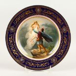 A VIENNA CIRCULAR PLATE "DAS IRRLICHT", within a blue and gold border. Inscribed. Beehive mark.