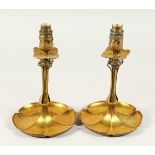 A GOOD PAIR OF ART NOUVEAU BRASS CANDLESTICKS with leaf bases. 26cms high.