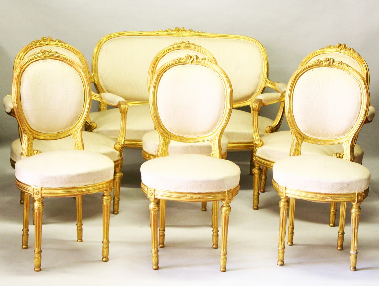 A GOOD LOUIS XVI STYLE GILTWOOD CANAPE, PAIR OF FAUTEUIL and four single chairs with padded backs,