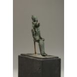 AN EARLY EGYPTIAN BRONZE FIGURE. 12cms long, on a stand.