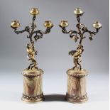 A SUPERB PAIR OF SILVER GILT THREE LIGHT CANDLESTICKS, with satyr holding three scrolling