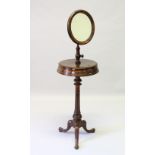 A VICTORIAN MAHOGANY SHAVING STAND with circular mirror, on turned pillar ending in tripod legs.