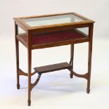 A GOOD EDWARDIAN MAHOGANY BIJOUTERIE TABLE with rising glass panel top, glass sides, on tapering
