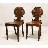 A GOOD PAIR OF REGENCY MAHOGANY HALL CHAIRS, with shaped backs, solid seats, on fluted legs.