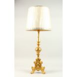 A FLORENTINE GILDED WOOD CANDLESTICK, converted to electricity, with a shade. 62cms high.