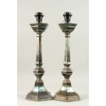 A HEAVY PAIR OF PLATED HEXAGONAL CANDLESTICKS, converted to lamps. 46cms high, one with a shade.