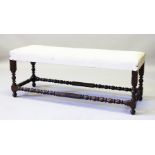 A GOOD LONG FOOTSTOOL with padded top on turned supports. 120cms long x 42cms wide.