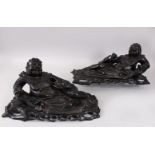 A PAIR OF CARVED HARDWOOD FIGURES OF RECLINING CHINESE MEN AND FROGS. 44cms long.