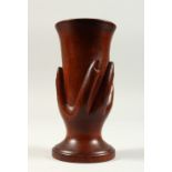 A PITCAIRN ISLAND CARVED WOOD HAND ON A VASE. 18cms high.