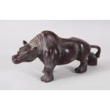 A CARVED WOOD FIGURE OF A RHINO. 29cms long.