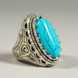 A SILVER AND TURQUOISE RING.