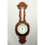 A CARVED OAK ANEROID BAROMETER. 83cms high.