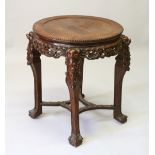 A CHINESE REDWOOD STAND, with inset hardstone top on carved legs. 73cms diameter.