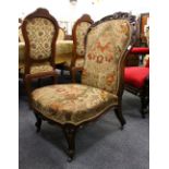 A VICTORIAN CARVED ROSEWOOD FRAMED NURSING CHAIR.