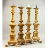 A GOOD PAIR OF ITALIAN CARVED WOOD AND GILDED PRICKET CANDLESTICKS, and two very similar, one