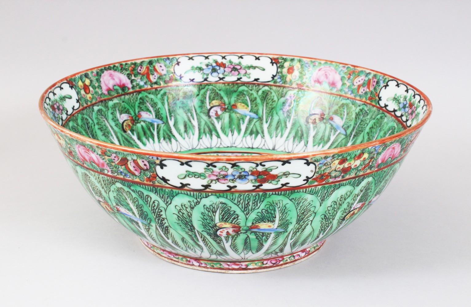 AN EARLY 20TH CENTURY CHINESE CANTON BUTTERFLY AND CABBAGE LEAF BOWL. 31cms diameter.