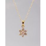 AN 18CT GOLD SEVEN STONE DIAMOND DAISY CLUSTER PENDANT, on a 9ct gold chain.