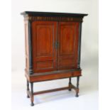 A 19TH CENTURY CAMPHOR WOOD CABINET ON STAND, with double panel doors enclosing two shelves, on a