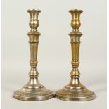 A PAIR OF PLATED CIRCULAR CANDLESTICKS. 26cms high.