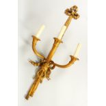 A LARGE SET OF FIVE THREE LIGHT WALL SCONCES, with curving trumpets and ribbon motifs. 114cms long.