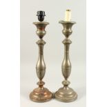 A PAIR OF METAL CANDLESTICKS, on circular bases converted to lamps. 48cms high.