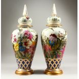 A PAIR OF VASES AND COVERS, decorated with flowers, birds and insects. 52cms high.